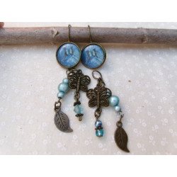 Boucles d'oreilles 2 paires en 1, un papillon bleu et noir sur un fond bleu sublime